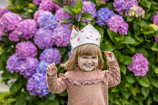 97 / 5000 Linda menina sorridente com uma coroa comemora seu aniversário, enquanto — Fotografia de Stock