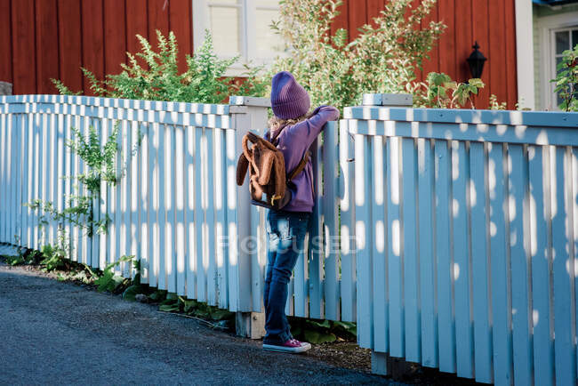 Портрет молодої дівчини, що спирається на ворота, думаючи про школу — стокове фото