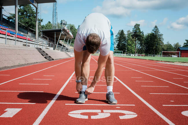Homme prêt à courir sur une piste de course — Photo de stock