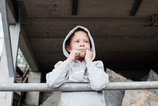 Portrait of a young boy in a sports hoody looking out over the track — Stock Photo