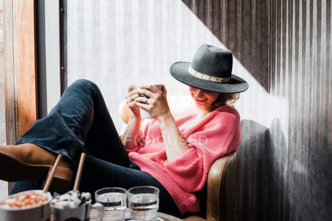 Donna pensando mentre beve una bevanda calda in un caffè in autunno — Foto stock