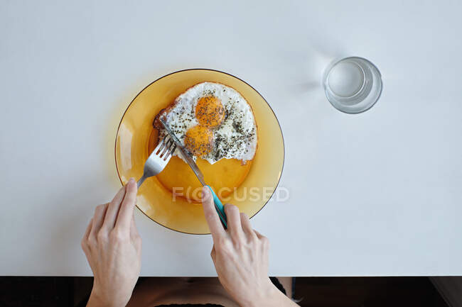 Mujer joven en lencería desayunando junto a la mesa - foto de stock