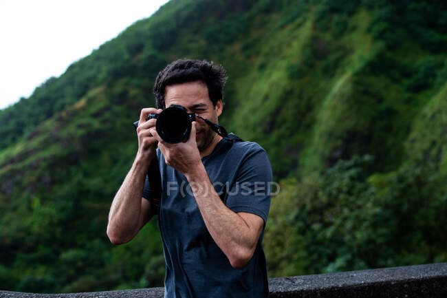El hombre toma fotos afuera en las montañas - foto de stock