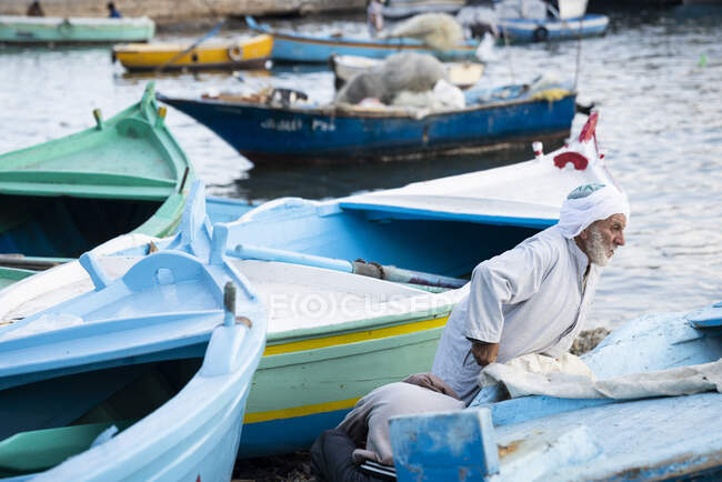 Un vieux pêcheur pousse son bateau — Photo de stock