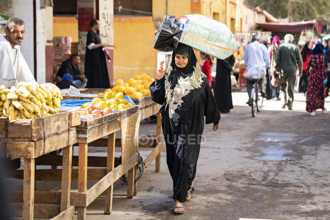 Femme égyptienne marche à travers un marché extérieur — Photo de stock