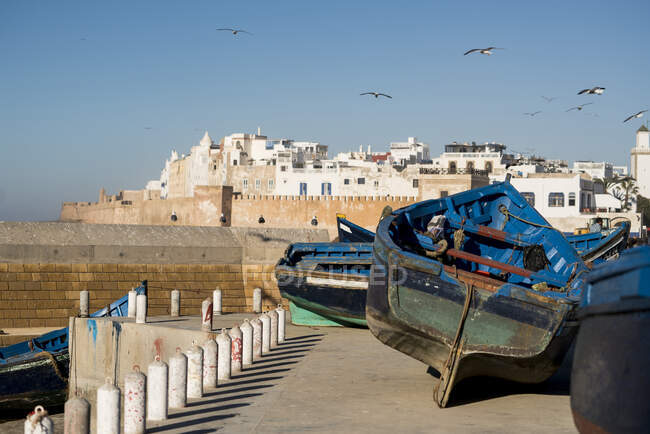 Coloridos barcos de pesca frente a la ciudad marroquí - foto de stock