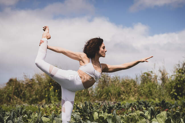 Yogi feminino na pose do dançarino em um campo — Fotografia de Stock