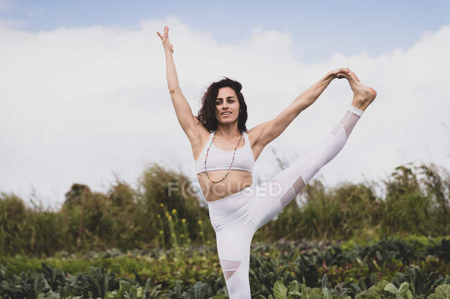 Femmina in posa yoga in un campo — Foto stock
