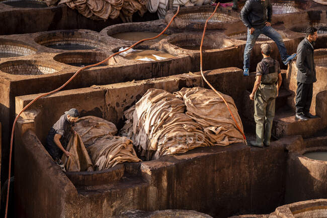Trabajadores marroquíes del cuero en la curtiduría de Fez - foto de stock