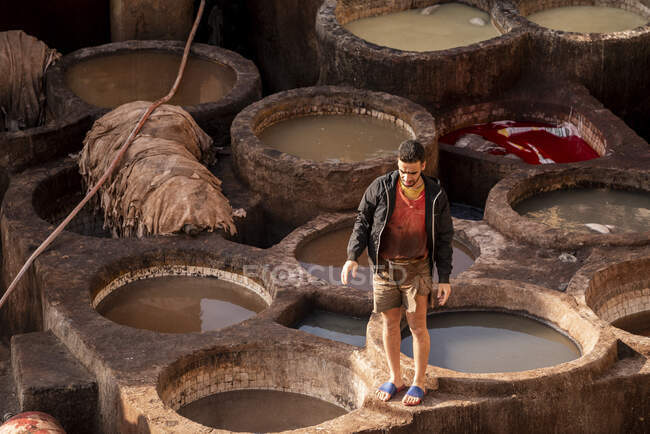 Hombre marroquí trabajando en curtiduría de cuero Fez - foto de stock