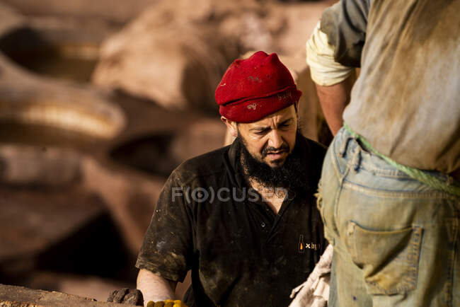 Двое мужчин работают вместе на кожевенном заводе в Фесе, Марокко — стоковое фото