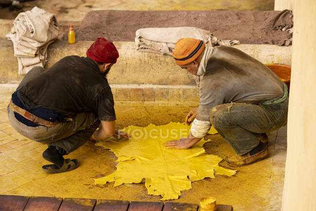 Мужчины, умирающие, прячутся в желтом на кожевенном заводе в Марокко — стоковое фото