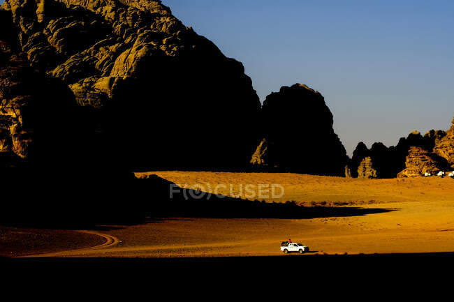 Um caminhão beduíno atravessa o deserto de Wadi Rum, Jordânia ao pôr do sol — Fotografia de Stock