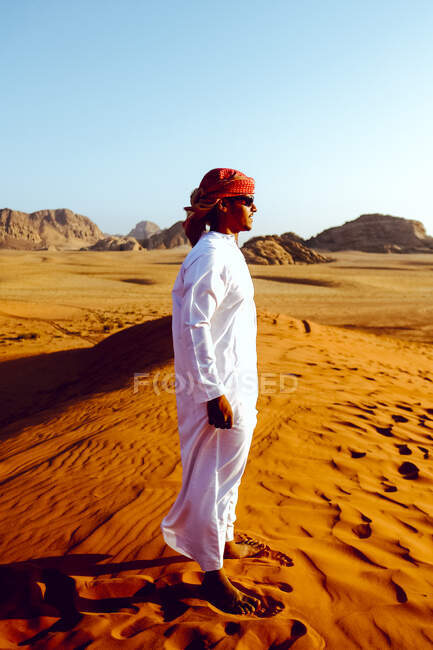 Ein Beduinenmann posiert auf einer Sanddüne im jordanischen Wadi Rum — Stockfoto
