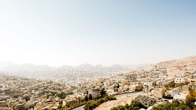Moderna ciudad de Wadi Musa, con Petra, Jordania al fondo - foto de stock