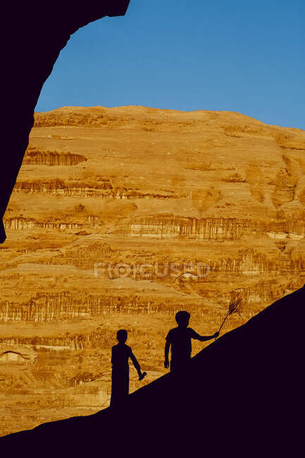 Два бедуина играют на скалах в Вади Рам, Иордания — стоковое фото