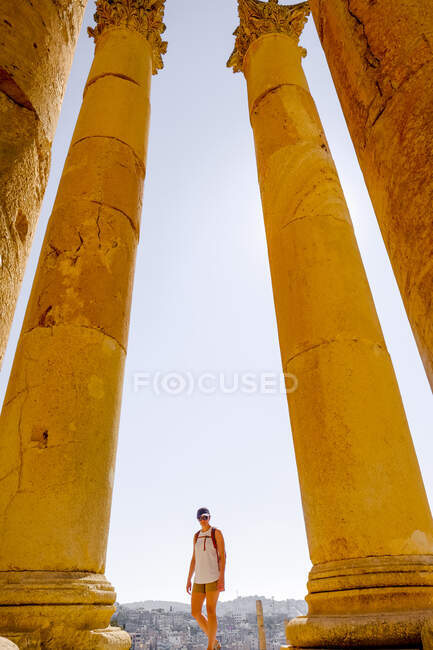 Eine Frau geht zwischen zerstörten römischen Säulen in Jerash, Jordanien — Stockfoto