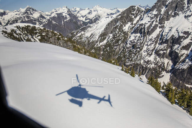 Sombra de helicóptero visto na paisagem montanhosa nevada — Fotografia de Stock