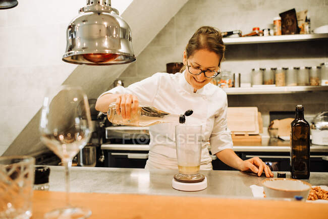 Female chef is working in a restaurant kitchen — Stock Photo