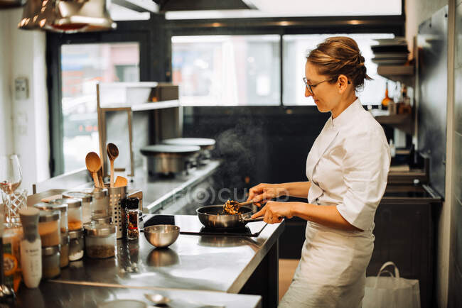 Female chef is working in a restaurant kitchen — Stock Photo