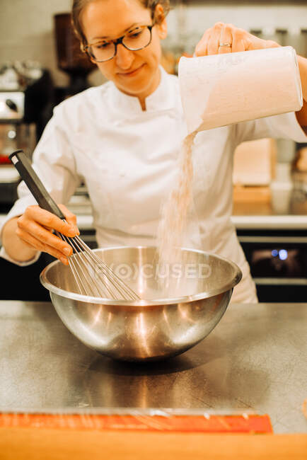 Chef mujer está preparando la masa para crepe en una cocina de restaurante, estilo de vida foto vertical - foto de stock