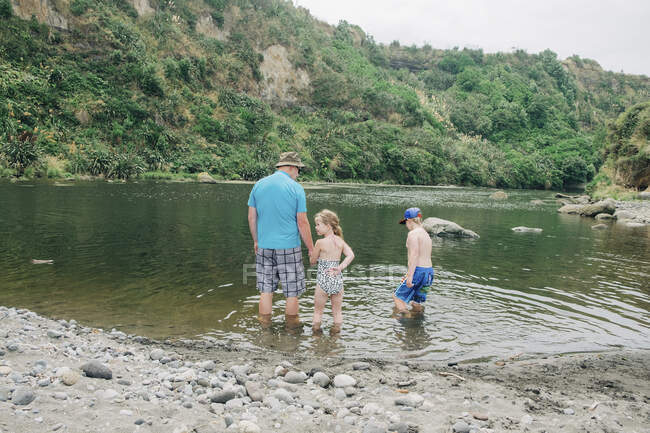 Семья играет в воде в живописном месте на реке — стоковое фото