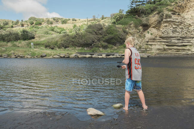 Giovane ragazzo pesca in un punto panoramico fiume — Foto stock