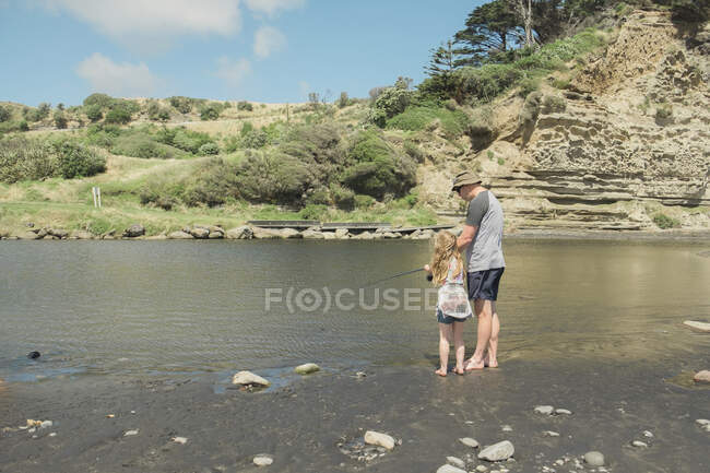 Pai e filha de pesca em um ponto de rio cênico — Fotografia de Stock