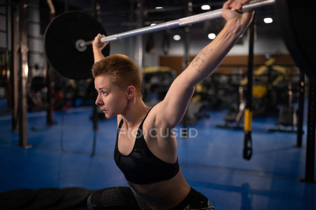 Strong athlete doing snatch exercise during functional workout in modern gym — Stock Photo