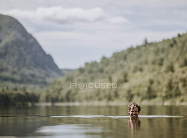 Man swims in smooth waters of South Branch Pond, Baxter State Park. — Stock Photo