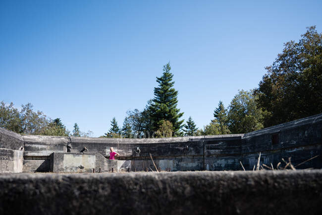 Blondes Mädchen mit rosa Hemd steht auf einem Bunker in Fort Worden, WA — Stockfoto