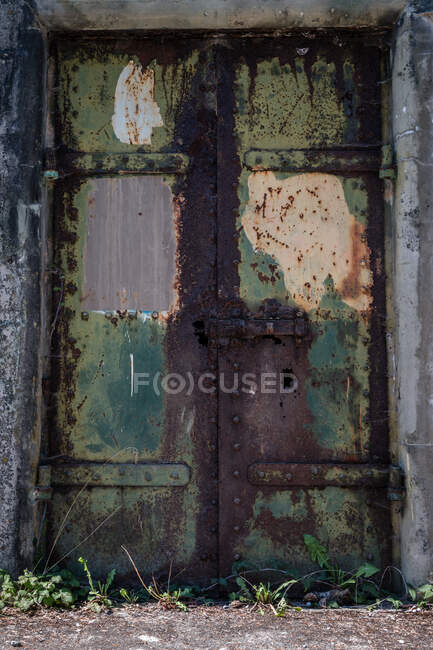 Rusty rustic metal door with green and yellow paint — Stock Photo