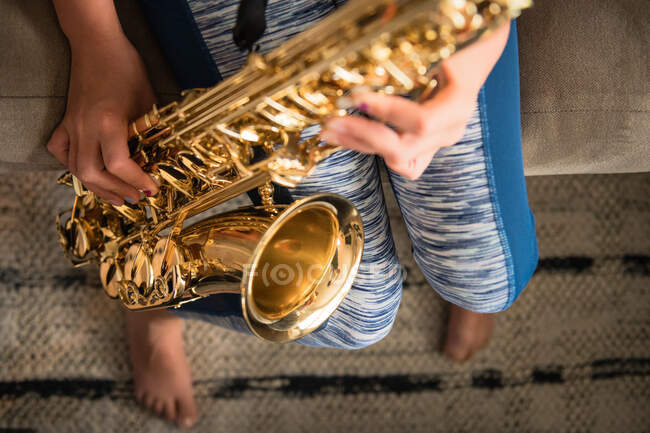 Child is playing saxophone at home — Stock Photo