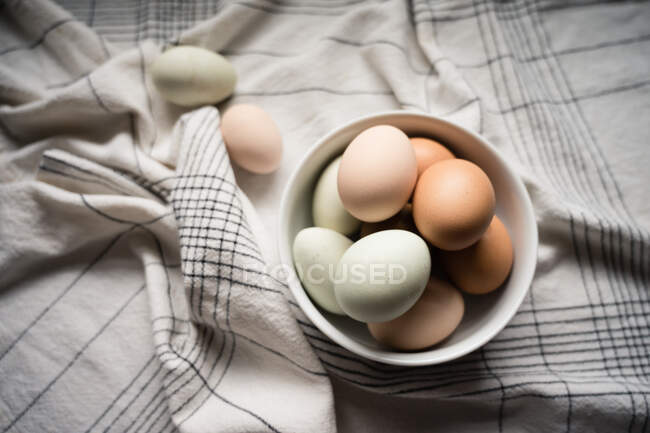 Ovos aninhados na tigela branca na mesa em casa — Fotografia de Stock