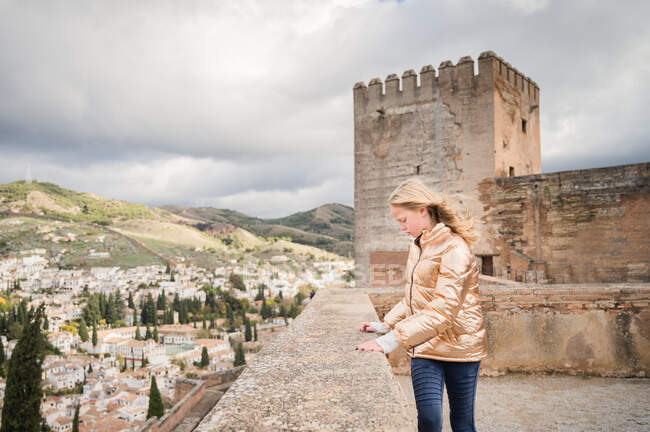 Дівчинка дивиться вниз на Гранаду з палацом Альгамбра на задньому плані — стокове фото