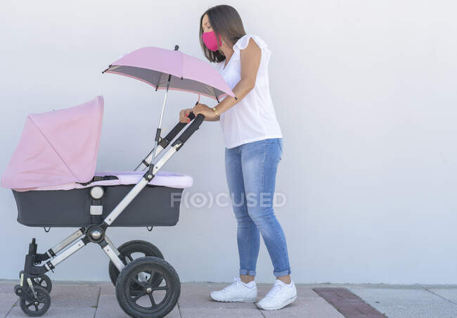 Mère marche avec son bébé dans son chariot — Photo de stock