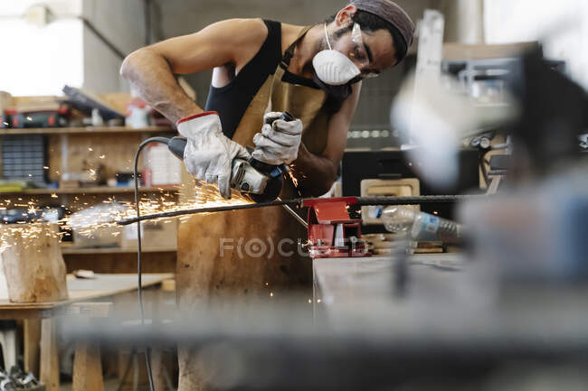 Männlicher Arbeiter schneidet Metall in Werkstatt — Stockfoto