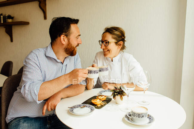 Щаслива пара снідає з пастеїсом де ната (традиційний португальський заварний тарт) і кавою в кафе.. — стокове фото