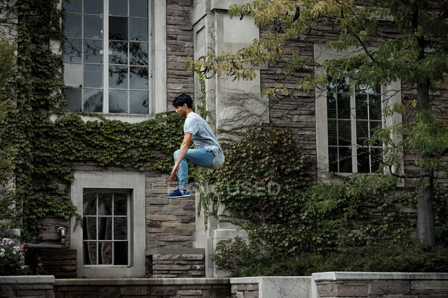 Male parkour athlete jumps through the air — Stock Photo