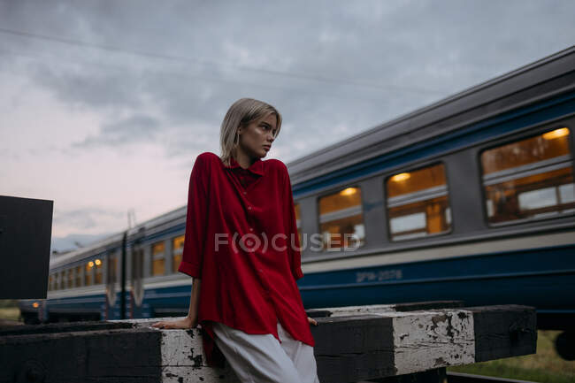 Giovane donna con giacca rossa e cappotto di pelle nera in città — Foto stock