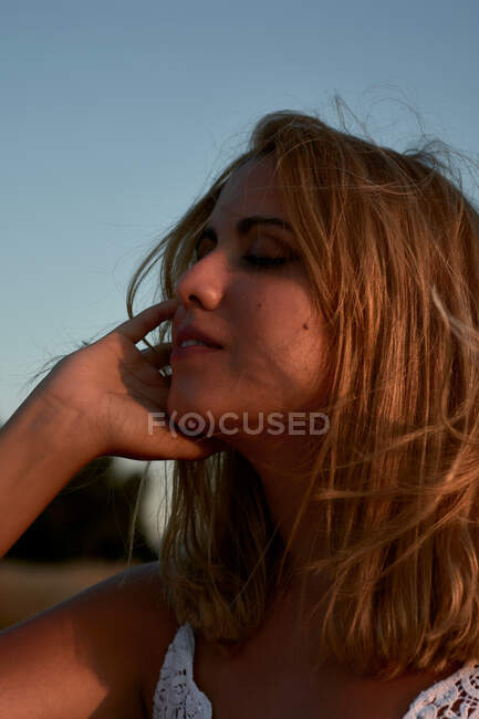 Una giovane donna chiude gli occhi mentre il vento le accarezza il viso — Foto stock