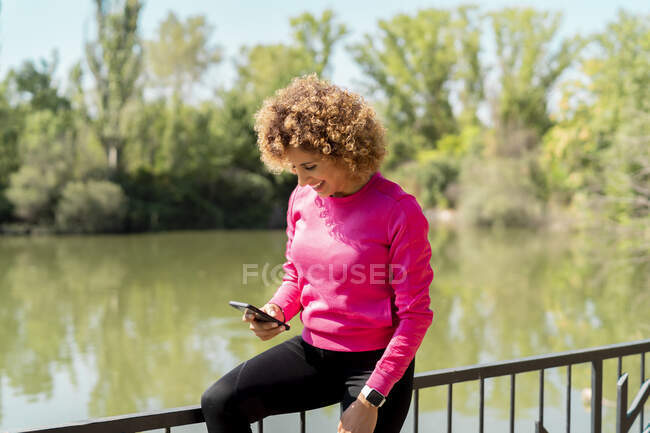 Atleta mulher usando seu smartphone — Fotografia de Stock