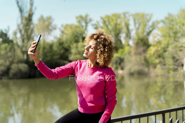 Спортивная женщина с помощью смартфона делает селфи — стоковое фото