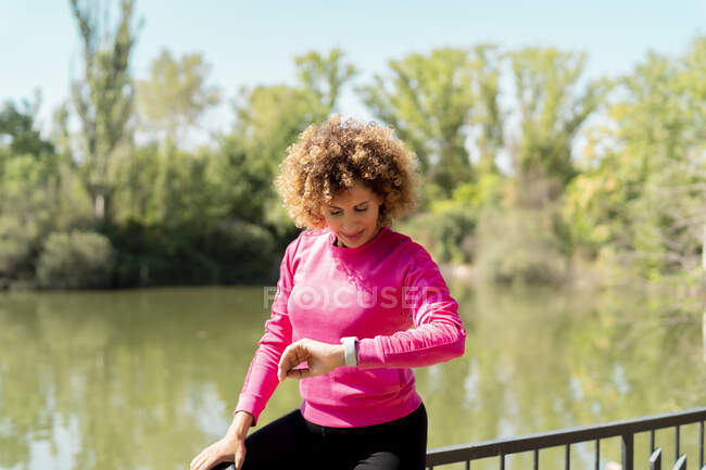 Atleta mujer usando smartwatch para controlar su ritmo cardíaco - foto de stock