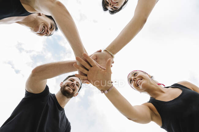 Vista in basso di un gruppo di persone motivate dal loro personal trainer all'aperto — Foto stock