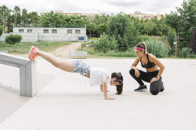 Junges Mädchen macht Liegestütze mit seinem Personal Trainer — Stockfoto