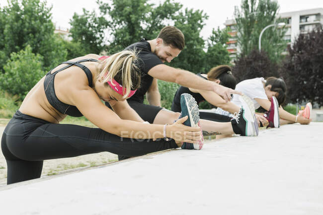 Группа людей растягивается на открытом воздухе после тренировки — стоковое фото
