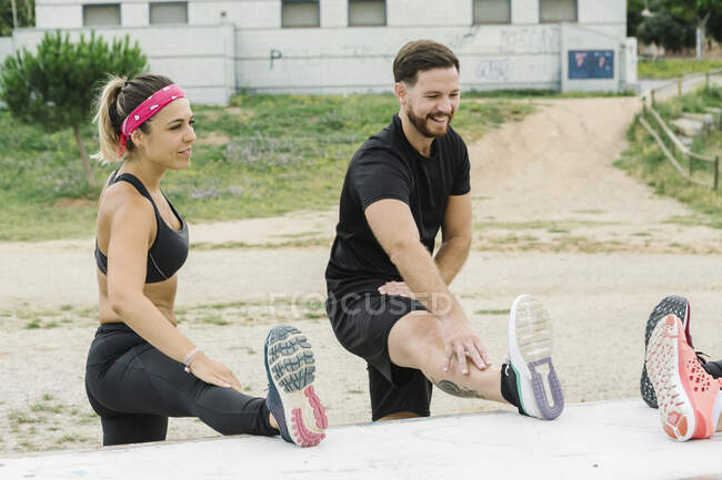 Junges Paar dehnt sich nach dem Training im Freien — Stockfoto