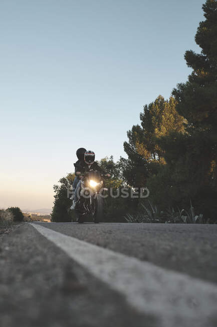 Couple riding a motorcycle on the road — Stock Photo