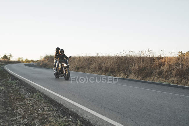 Coppia che guida una moto su strada — Foto stock